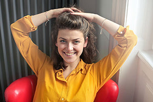 a girl smiling and touching her hair