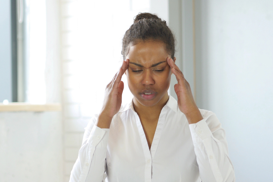 a woman is suffering from a headache