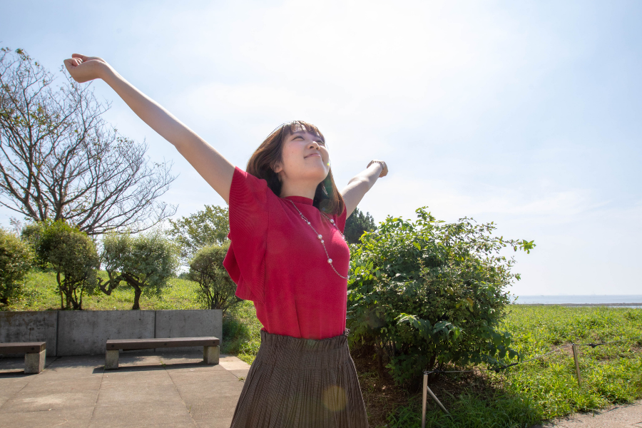 Woman taking deep, healthy breath in the sunshine.